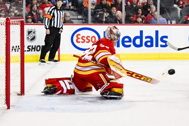 Feb 15, 2024; Calgary, Alberta, CAN; Calgary Flames goaltender Dustin Wolf (32) makes a save against the San Jose Sharks during the first period at Scotiabank Saddledome. Mandatory Credit: Brett Holmes-USA TODAY Sports