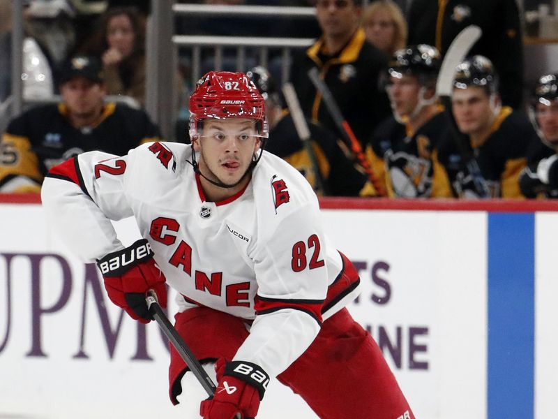 Oct 18, 2024; Pittsburgh, Pennsylvania, USA;  Carolina Hurricanes center Jesperi Kotkaniemi (82) skates up ice with the puck against the Pittsburgh Penguins during the second period at PPG Paints Arena. Mandatory Credit: Charles LeClaire-Imagn Images