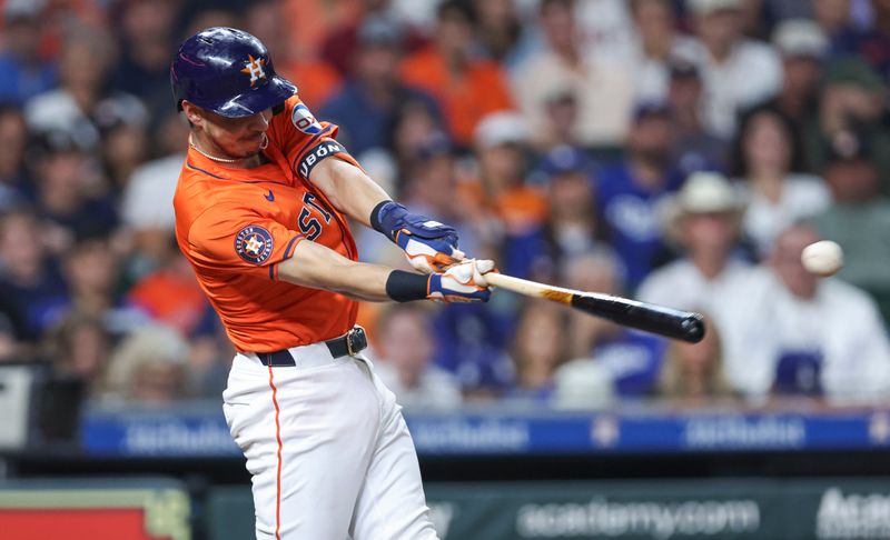 Jul 26, 2024; Houston, Texas, USA; Houston Astros left fielder Mauricio Dubon (14) hits a double during the eighth inning against the Los Angeles Dodgers at Minute Maid Park. Mandatory Credit: Troy Taormina-USA TODAY Sports