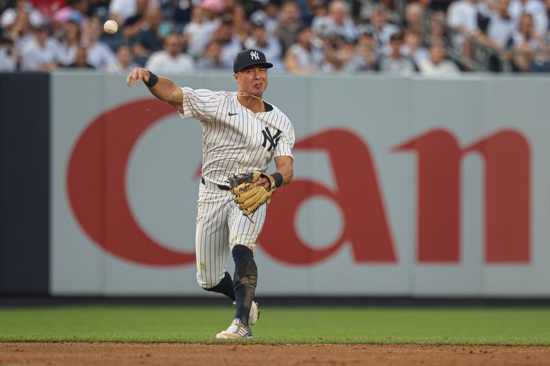 Jun 5, 2024; Bronx, New York, USA; New York Yankees shortstop Anthony Volpe (11) throws the ball to first base for an out during the third inning against the Minnesota Twins at Yankee Stadium. Mandatory Credit: Vincent Carchietta-USA TODAY Sports