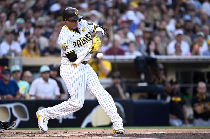 Aug 13, 2024; San Diego, California, USA; San Diego Padres third baseman Manny Machado (13) hits a sacrifice fly against the Pittsburgh Pirates during the first inning at Petco Park. Mandatory Credit: Orlando Ramirez-USA TODAY Sports