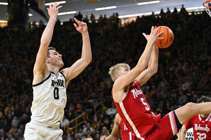 Mar 5, 2023; Iowa City, Iowa, USA; Nebraska Cornhuskers guard Sam Griesel (5) grabs a rebound in front of Iowa Hawkeyes forward Filip Rebraca (0) during the second half at Carver-Hawkeye Arena. Mandatory Credit: Jeffrey Becker-USA TODAY Sports