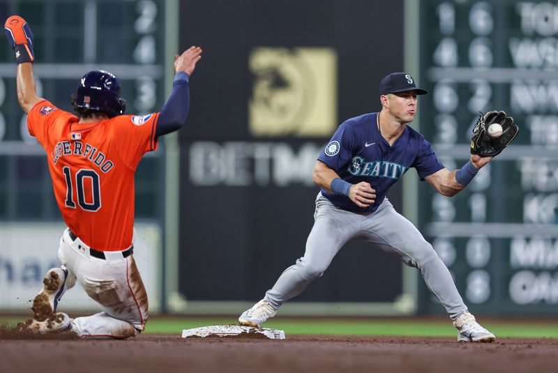 May 3, 2024; Houston, Texas, USA; Houston Astros left fielder Joey Loperfido (10) is out at second base as Seattle Mariners shortstop Dylan Moore (25) fields a throw during the third inning at Minute Maid Park. Mandatory Credit: Troy Taormina-USA TODAY Sports