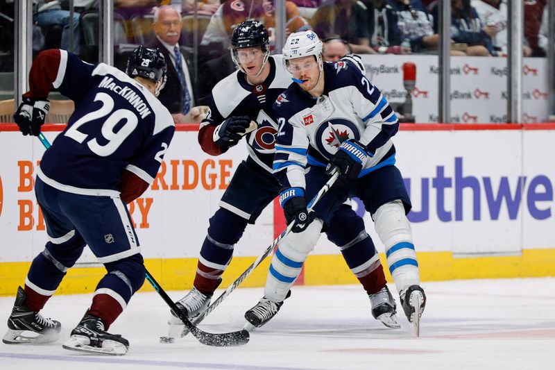 Apr 13, 2024; Denver, Colorado, USA; Winnipeg Jets center Mason Appleton (22) controls the puck under pressure from Colorado Avalanche center Nathan MacKinnon (29) and defenseman Josh Manson (42) in the third period at Ball Arena. Mandatory Credit: Isaiah J. Downing-USA TODAY Sports