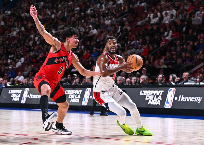 MONTREAL, CANADA - OCTOBER 06: Jared Butler #4 of the Washington Wizards dribbles the ball against D.J. Carton #3 of the Toronto Raptors during the second half of a preseason NBA game at the Bell Centre on October 6, 2024 in Montreal, Quebec, Canada. The Toronto Raptors defeated the Washington Wizards 125-98. NOTE TO USER: User expressly acknowledges and agrees that, by downloading and or using this photograph, User is consenting to the terms and conditions of the Getty Images License Agreement. (Photo by Minas Panagiotakis/Getty Images)