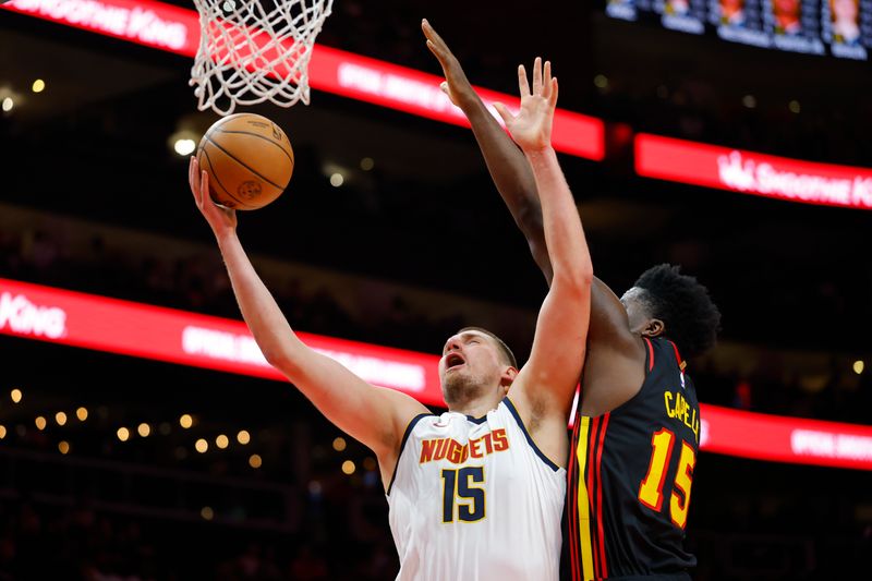 ATLANTA, GEORGIA - DECEMBER 08: Nikola Jokic #15 of the Denver Nuggets goes up for a shot against Clint Capela #15 of the Atlanta Hawks during the first quarter at State Farm Arena on December 8, 2024 in Atlanta, Georgia. NOTE TO USER: User expressly acknowledges and agrees that, by downloading and or using this photograph, User is consenting to the terms and conditions of the Getty Images License Agreement. (Photo by Todd Kirkland/Getty Images)