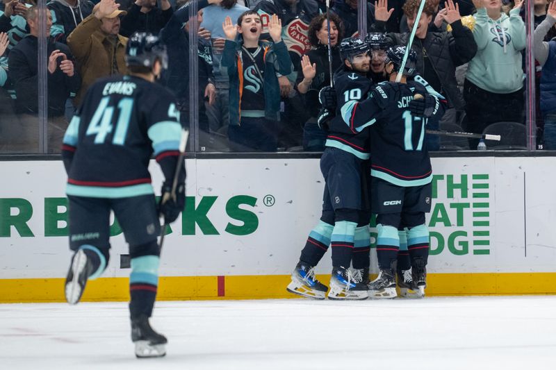 Jan 28, 2025; Seattle, Washington, USA;  Seattle Kraken forward Matty Beniers (10), forward Kaapo Kakko (84), second from right, and forward Jaden Schwartz (17) celebrate a goal during the first period against the Anaheim Ducks at Climate Pledge Arena. Mandatory Credit: Stephen Brashear-Imagn Images