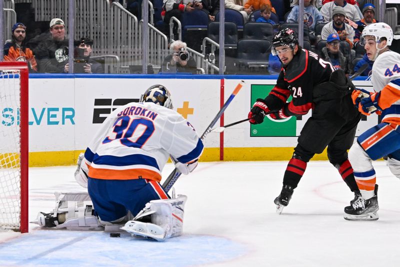 Mar 19, 2024; Elmont, New York, USA; Carolina Hurricanes center Seth Jarvis (24) scores a goal past New York Islanders goaltender Ilya Sorokin (30) during the first period at UBS Arena. Mandatory Credit: Dennis Schneidler-USA TODAY Sports