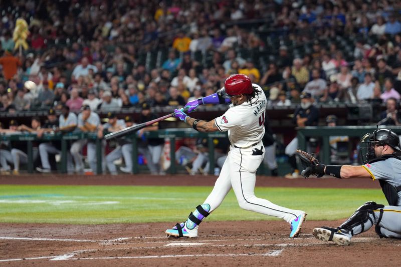 Jul 26, 2024; Phoenix, Arizona, USA; Arizona Diamondbacks second base Ketel Marte (4) hits a sacrifice fly RBI against the Pittsburgh Pirates during the third inning at Chase Field. Mandatory Credit: Joe Camporeale-USA TODAY Sports