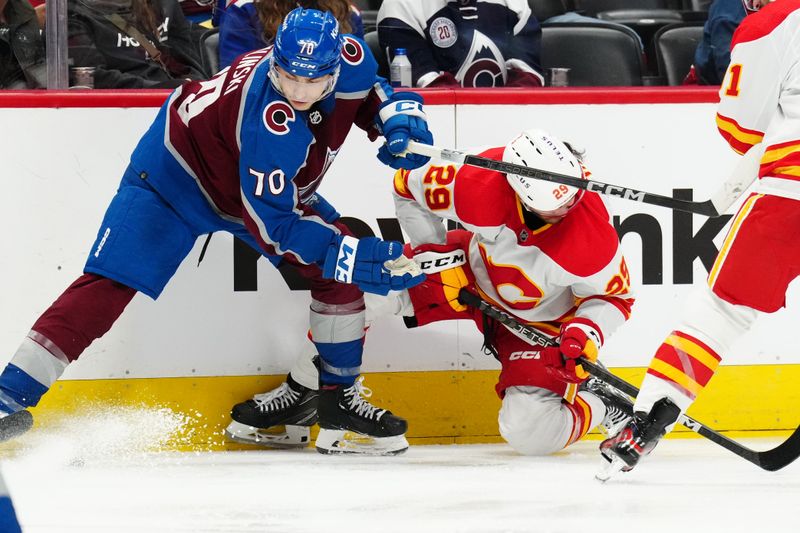 Dec 11, 2023; Denver, Colorado, USA; Colorado Avalanche defenseman Sam Malinski (70) hits Calgary Flames center Dillon Dube (29) in the third period at Ball Arena. Mandatory Credit: Ron Chenoy-USA TODAY Sports