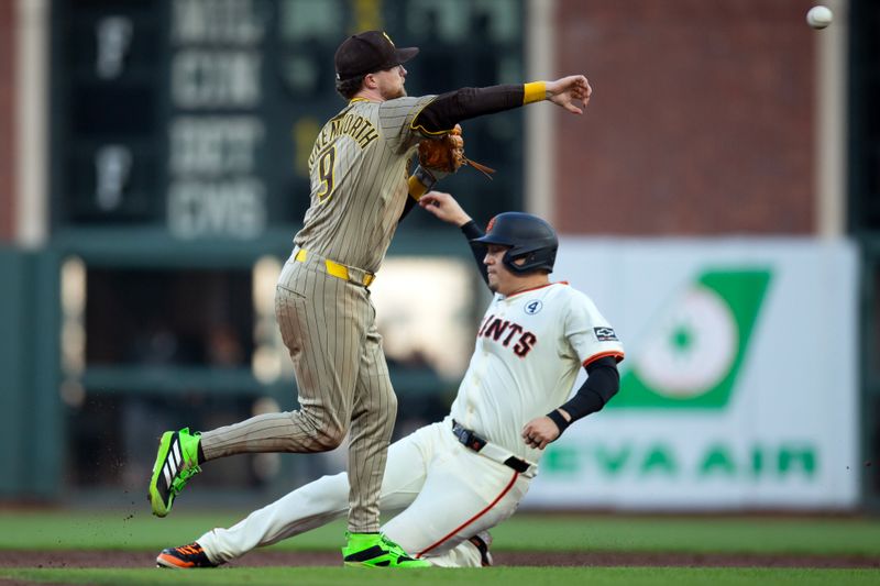 Jun 2, 2025; San Francisco, California, USA; San Diego Padres second baseman Jake Cronenworth (9) throws over San Francisco Giants designated hitter Wilmer Flores (41) to complete a double play during the third inning at Oracle Park. Mandatory Credit: D. Ross Cameron-Imagn Images