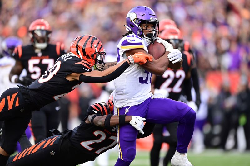 Minnesota Vikings running back Ty Chandler (32) carries the ball during an NFL football game against the Cincinnati Bengals on Saturday, Dec. 16, 2023, in Cincinnati. (AP Photo/Emilee Chinn)