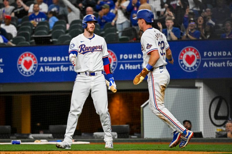 Apr 10, 2024; Arlington, Texas, USA; Texas Rangers catcher Jonah Heim (28) and left fielder Evan Carter (32) celebrates after Carter scores against the Oakland Athletics during the first inning at Globe Life Field. Mandatory Credit: Jerome Miron-USA TODAY Sports