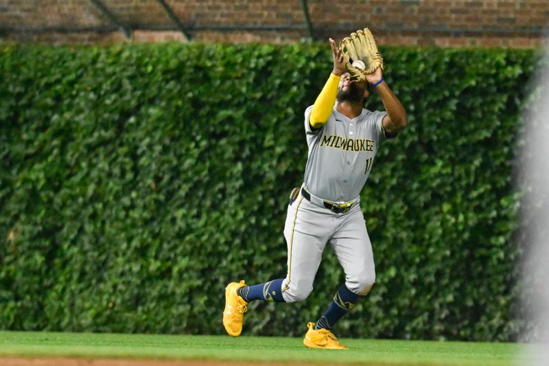 Jul 23, 2024; Chicago, Illinois, USA;  Milwaukee Brewers outfielder Jackson Chourio (11) catches a fly ball hit by Chicago Cubs outfielder Mike Tauchman (40) during the second inning at Wrigley Field. Mandatory Credit: Matt Marton-USA TODAY Sports