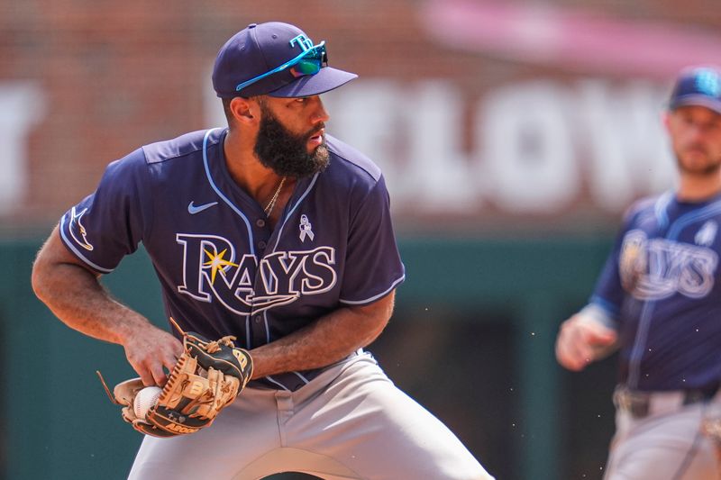 Jun 16, 2024; Cumberland, Georgia, USA; Tampa Bay Rays shortstop Amed Rosario (10) has trouble with the ball preventing a double play against the Atlanta Braves during the ninth inning at Truist Park. Mandatory Credit: Dale Zanine-USA TODAY Sports