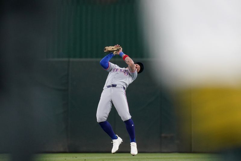 Apr 23, 2025; West Sacramento, California, USA; Texas Rangers center fielder Kevin Pillar (1) makes a catch against the Athletics in the fourth inning at Sutter Health Park. Mandatory Credit: Cary Edmondson-Imagn Images
