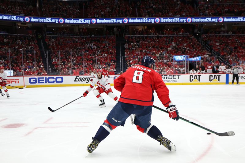 May 6, 2025; Washington, District of Columbia, USA; Washington Capitals left wing Alex Ovechkin (8) shoots the puck as Carolina Hurricanes center Mark Jankowski (77) defends in the first period in game one of the second round of the 2025 Stanley Cup Playoffs at Capital One Arena. Mandatory Credit: Geoff Burke-Imagn Images