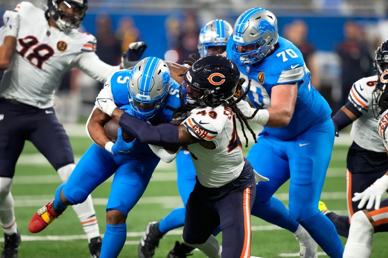 Chicago Bears linebacker Tremaine Edmunds (49) tackles Detroit Lions running back David Montgomery (5) during the first half of an NFL football game, Sunday, Nov. 17, 2024, in Detroit. (AP Photo/Carlos Osorio)