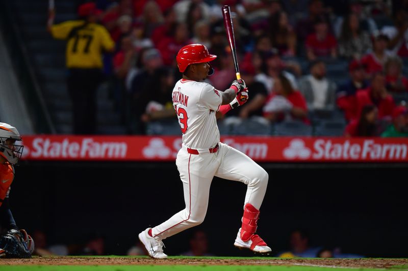 Sep 26, 2025; Anaheim, California, USA; Los Angeles Angels shortstop Denzer Guzman (13) hits an RBI double against the Houston Astros during the fifth inning at Angel Stadium. Mandatory Credit: Gary A. Vasquez-Imagn Images