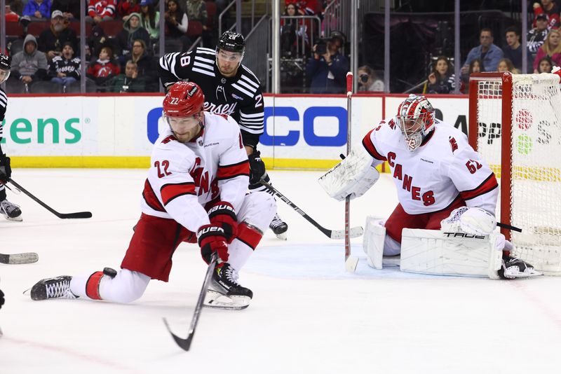 Mar 9, 2024; Newark, New Jersey, USA; Carolina Hurricanes defenseman Brett Pesce (22) blocks a shot against the New Jersey Devils during the second period at Prudential Center. Mandatory Credit: Ed Mulholland-USA TODAY Sports