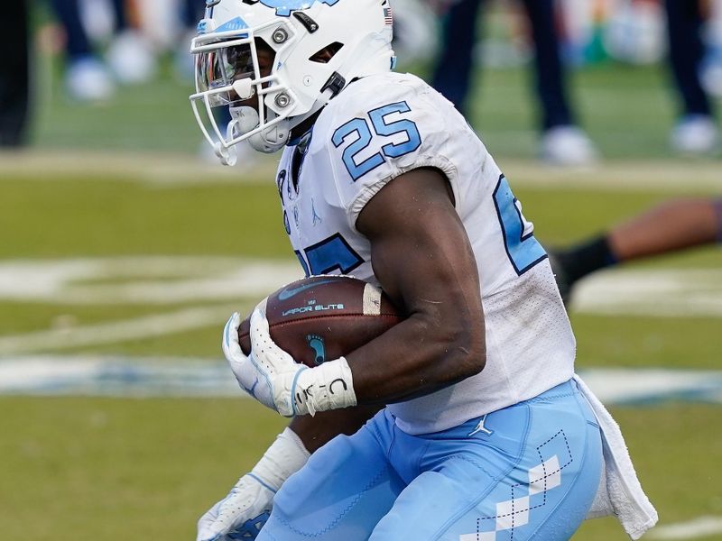 Nov 7, 2020; Durham, North Carolina, USA; North Carolina Tar Heels running back Javonte Williams (25) runs through the line against the Duke Blue Devils during the second half at Wallace Wade Stadium. Mandatory Credit: Jim Dedmon-USA TODAY Sports