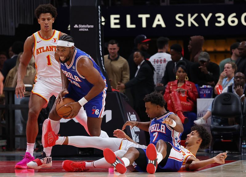 ATLANTA, GEORGIA - OCTOBER 14:  Guerschon Yabusele #28 of the Philadelphia 76ers picks up a loose ball from Kyle Lowry #7 against Zaccharie Risacher #10 and Jalen Johnson #1 of the Atlanta Hawks during the second quarter at State Farm Arena on October 14, 2024 in Atlanta, Georgia.  NOTE TO USER: User expressly acknowledges and agrees that, by downloading and/or using this photograph, user is consenting to the terms and conditions of the Getty Images License Agreement.  (Photo by Kevin C. Cox/Getty Images)