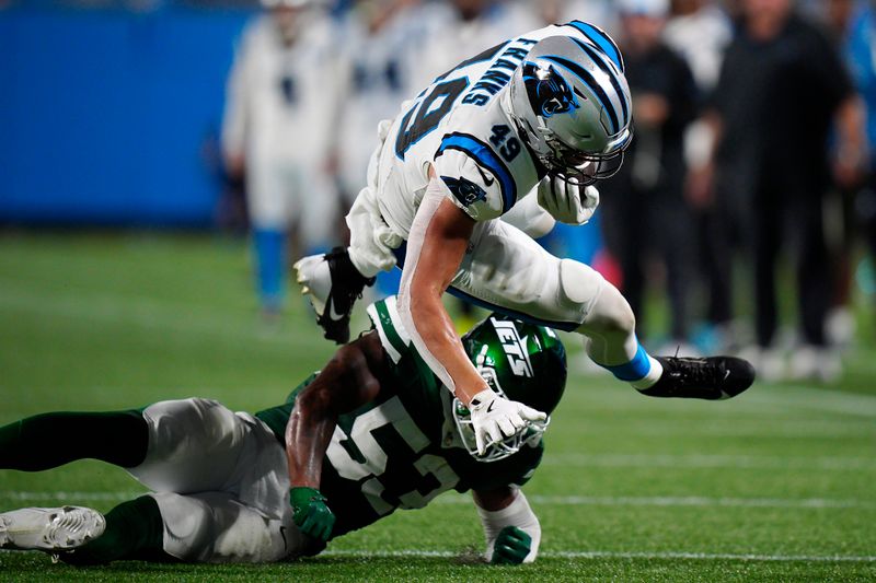 Carolina Panthers tight end Feleipe Franks, top, is tackled by New York Jets linebacker Zaire Barnes during the second half of a preseason NFL football game, Saturday, Aug. 17, 2024, in Charlotte, N.C. (AP Photo/Jacob Kupferman)