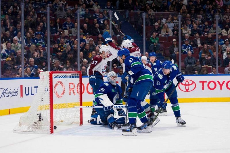 Mar 13, 2024; Vancouver, British Columbia, CAN; Colorado Avalanche forward Casey Mittelstadt (37) and Vancouver Canucks forward Elias Lindholm (23) and defenseman Noah Juulsen (47) watch as forward Mikko Rantanen (96) scores on goalie Casey DeSmith (29) in the second period at Rogers Arena. Mandatory Credit: Bob Frid-USA TODAY Sports