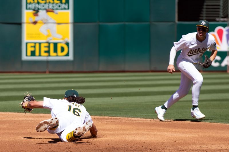 Sep 8, 2024; Oakland, California, USA; Oakland Athletics first baseman Tristan Gray (16) makes a diving stop of a sharp ground ball by Detroit Tigers second baseman Colt Keith (33) before throwing him out at first base during the third inning at Oakland-Alameda County Coliseum. Mandatory Credit: D. Ross Cameron-Imagn Images