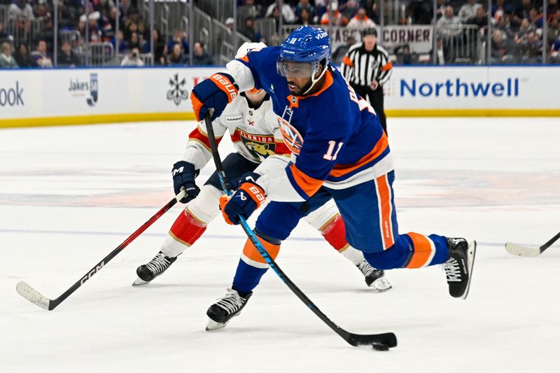Mar 1, 2026; Elmont, New York, USA;  New York Islanders left wing Anthony Duclair (11) attempts a shot against the Florida Panthers during the first period at UBS Arena. Mandatory Credit: Dennis Schneidler-Imagn Images