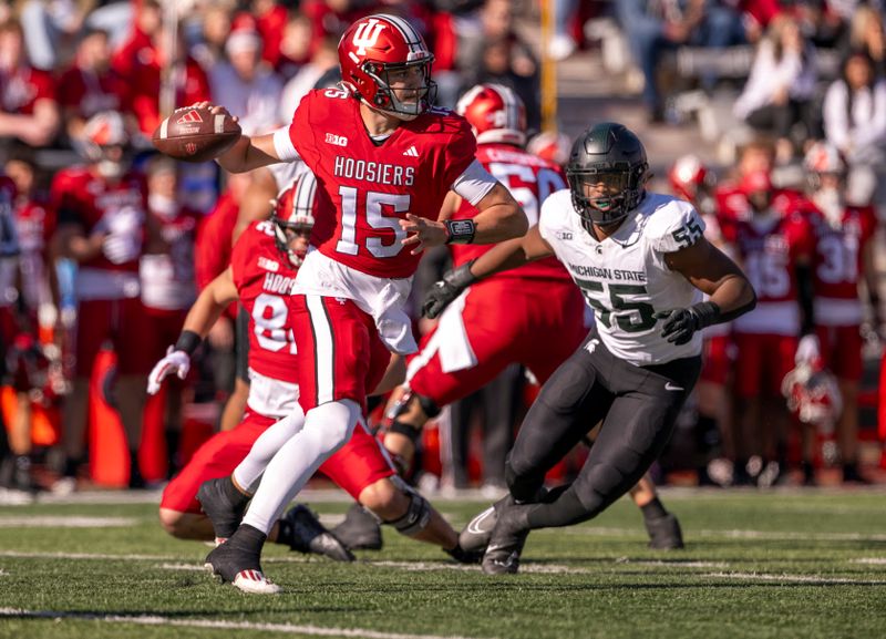 Nov 18, 2023; Bloomington, Indiana, USA; Indiana Hoosiers quarterback Brendan Sorsby (15) prepares to throw the ball under pressure from Michigan State Spartans defensive lineman Jalen Thompson (55) during the first quarter at Memorial Stadium. Mandatory Credit: Marc Lebryk-USA TODAY Sports