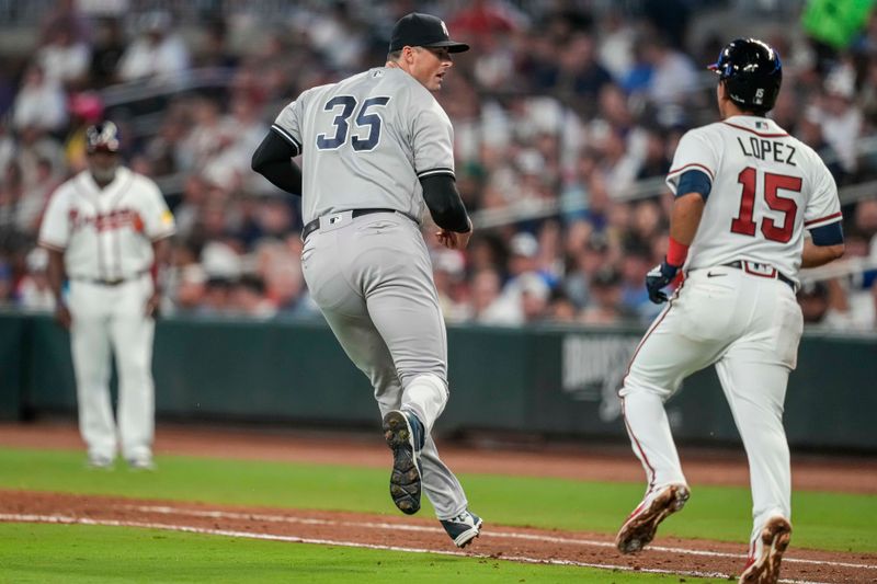 Aug 15, 2023; Cumberland, Georgia, USA; New York Yankees relief pitcher Clay Holmes (35) fields a ground ball hit by Atlanta Braves second baseman Nicky Lopez (15) before throwing him out at first base during the eighth inning at Truist Park. Mandatory Credit: Dale Zanine-USA TODAY Sports