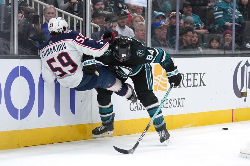 Feb 17, 2024; San Jose, California, USA; San Jose Sharks defenseman Jan Rutta (84) checks Columbus Blue Jackets right wing Yegor Chinakhov (59) during the first period at SAP Center at San Jose. Mandatory Credit: Darren Yamashita-USA TODAY Sports