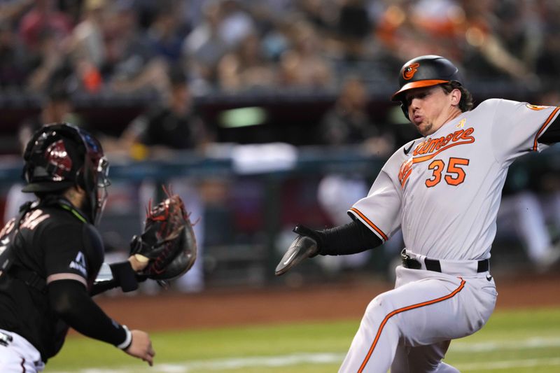 Sep 3, 2023; Phoenix, Arizona, USA; Baltimore Orioles catcher Adley Rutschman (35) is unable to beat a throw to Arizona Diamondbacks catcher Jose Herrera (11) as he is tagged out at home during the first inning at Chase Field. Mandatory Credit: Joe Camporeale-USA TODAY Sports