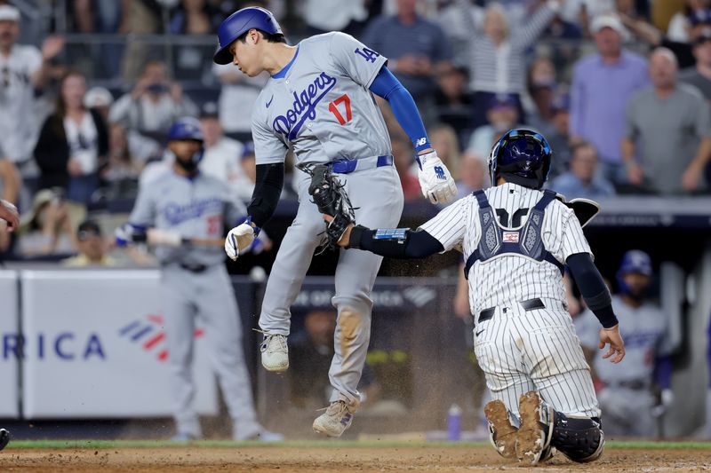 Jun 9, 2024; Bronx, New York, USA; Los Angeles Dodgers designated hitter Shohei Ohtani (17) scores ahead of the tag by New York Yankees catcher Jose Trevino (39) on a sacrifice fly by Dodgers catcher Will Smith (not pictured) during the eighth inning at Yankee Stadium. Mandatory Credit: Brad Penner-USA TODAY Sports