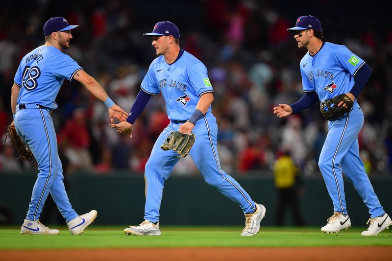 Aug 12, 2024; Anaheim, California, USA; Toronto Blue Jays first baseman Spencer Horwitz (48) second baseman Will Wagner (7) and  left fielder Joey Loperfido (9) celebrate the victory against the Los Angeles Angels at Angel Stadium. Mandatory Credit: Gary A. Vasquez-USA TODAY Sports