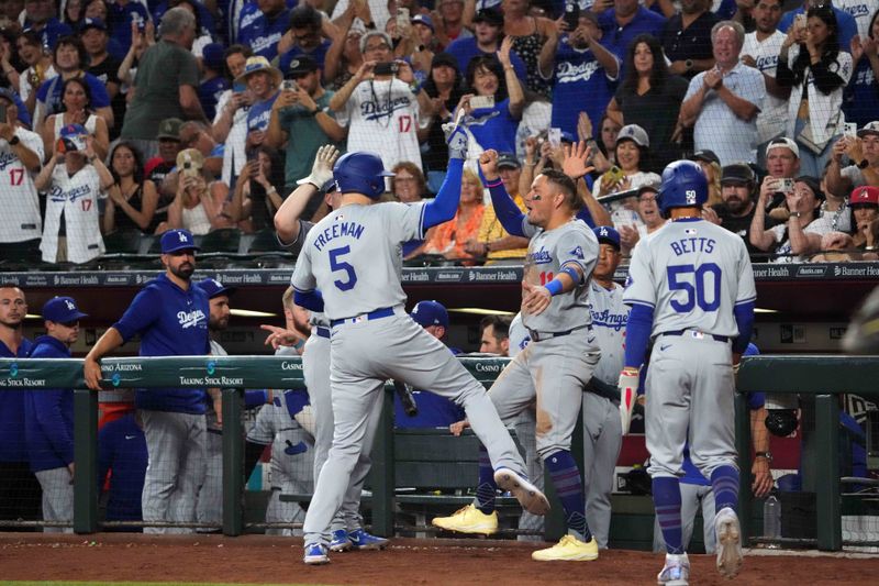 Sep 2, 2024; Phoenix, Arizona, USA; Los Angeles Dodgers first base Freddie Freeman (5) celebrates with Los Angeles Dodgers shortstop Miguel Rojas (11)  after hitting a home run against the Arizona Diamondbacks during the eighth inning at Chase Field. Mandatory Credit: Joe Camporeale-USA TODAY Sports