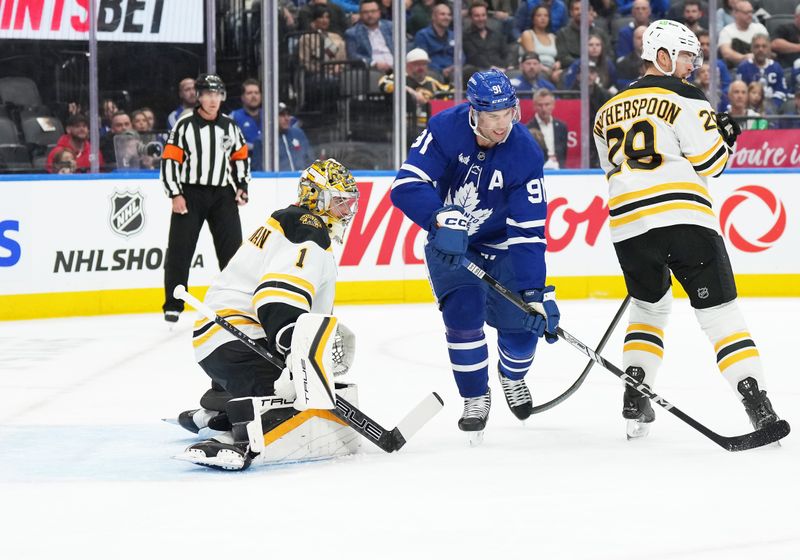 Nov 5, 2024; Toronto, Ontario, CAN; Toronto Maple Leafs center John Tavares (91) battles with Boston Bruins center Elias Lindholm (28) in front of goaltender Jeremy Swayman (1) during the first period at Scotiabank Arena. Mandatory Credit: Nick Turchiaro-Imagn Imagess