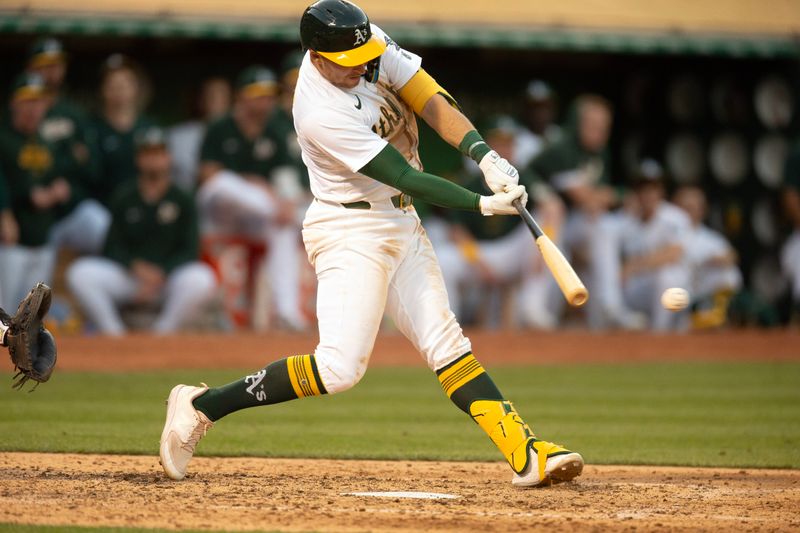 Jul 3, 2024; Oakland, California, USA; Oakland Athletics third baseman Brett Harris (77) connects for an RBI single against the Los Angeles Angels during the sixth inning at Oakland-Alameda County Coliseum. Mandatory Credit: D. Ross Cameron-USA TODAY Sports