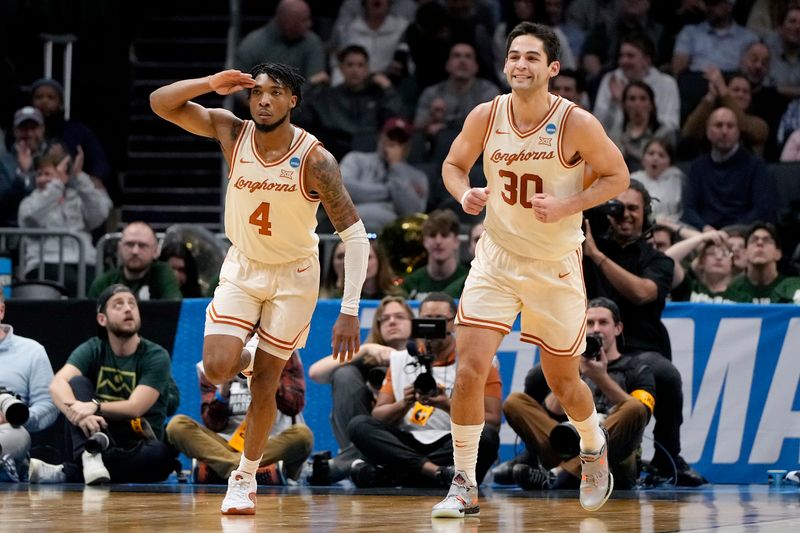 Mar 21, 2024; Charlotte, NC, USA; Texas Longhorns guard Tyrese Hunter (4) and Texas Longhorns forward Brock Cunningham (30) celebrate a play in the first half of the first round of the 2024 NCAA Tournament at Spectrum Center. Mandatory Credit: Bob Donnan-USA TODAY Sports