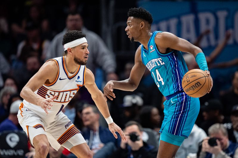 CHARLOTTE, NORTH CAROLINA - MARCH 15: Devin Booker #1 of the Phoenix Suns guards Brandon Miller #24 of the Charlotte Hornets in the fourth quarter during their game at Spectrum Center on March 15, 2024 in Charlotte, North Carolina. NOTE TO USER: User expressly acknowledges and agrees that, by downloading and or using this photograph, User is consenting to the terms and conditions of the Getty Images License Agreement. (Photo by Jacob Kupferman/Getty Images)