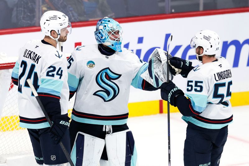 Oct 23, 2025; Winnipeg, Manitoba, CAN; Seattle Kraken defenseman Jamie Oleksiak (24), Seattle Kraken goaltender Joey Daccord (35) and Seattle Kraken defenseman Ryan Lindgren (55) celebrate their victory against the Winnipeg Jets at Canada Life Centre. Mandatory Credit: James Carey Lauder-Imagn Images