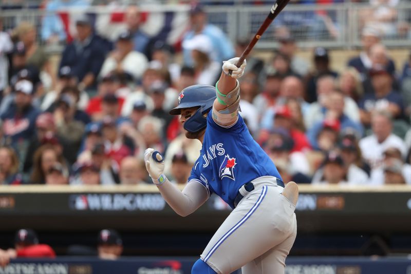 Oct 4, 2023; Minneapolis, Minnesota, USA;Toronto Blue Jays shortstop Bo Bichette (11) hits a single in the first inning against the Minnesota Twins during game two of the Wildcard series for the 2023 MLB playoffs at Target Field. Mandatory Credit: Jesse Johnson-USA TODAY Sports