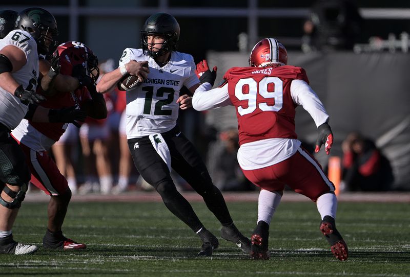 Nov 18, 2023; Bloomington, Indiana, USA; Michigan State Spartans quarterback Katin Houser (12) jukes past Indiana Hoosiers defensive lineman Nick James (99) during the second half at Memorial Stadium. Mandatory Credit: Marc Lebryk-USA TODAY Sports