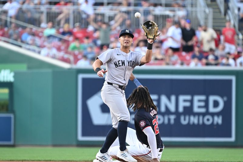 Aug 27, 2024; Washington, District of Columbia, USA; New York Yankees shortstop Anthony Volpe (11) catches the ball in front of Washington Nationals left fielder James Wood (29) at second base during the first inning at Nationals Park. Mandatory Credit: Rafael Suanes-USA TODAY Sports