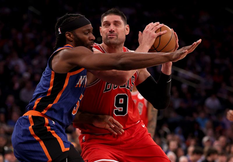 NEW YORK, NEW YORK - APRIL 14: Nikola Vucevic #9 of the Chicago Bulls heads for the net as Precious Achiuwa #5 of the New York Knicks defends during the second half at Madison Square Garden on April 14, 2024 in New York City. The New York Knicks defeated the Chicago Bulls 120-119 in OT. NOTE TO USER: User expressly acknowledges and agrees that, by downloading and or using this photograph, User is consenting to the terms and conditions of the Getty Images License Agreement. (Photo by Elsa/Getty Images)