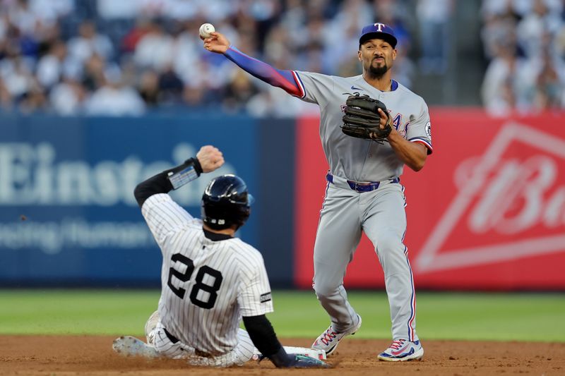 May 20, 2025; Bronx, New York, USA; Texas Rangers second baseman Marcus Semien (2) forces out New York Yankees catcher Austin Wells (28) at second base then throws to first to complete a double play on a ball hit by Yankees third baseman Oswald Peraza (not pictured) during the third inning at Yankee Stadium. Mandatory Credit: Brad Penner-Imagn Images