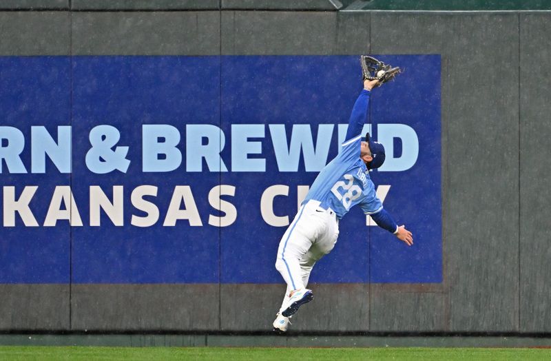 Apr 25, 2024; Kansas City, Missouri, USA;  Kansas City Royals center fielder Kyle Isbel (28) makes a leaping catch against Toronto Blue Jays George Springer (not pictured) in the fifth inning at Kauffman Stadium. Mandatory Credit: Peter Aiken-USA TODAY Sports