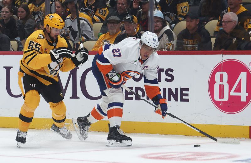 Oct 9, 2025; Pittsburgh, Pennsylvania, USA;  New York Islanders left wing Anders Lee (27) moves the puck against pressure from Pittsburgh Penguins defenseman Erik Karlsson (65) during the second period at PPG Paints Arena. Mandatory Credit: Charles LeClaire-Imagn Images