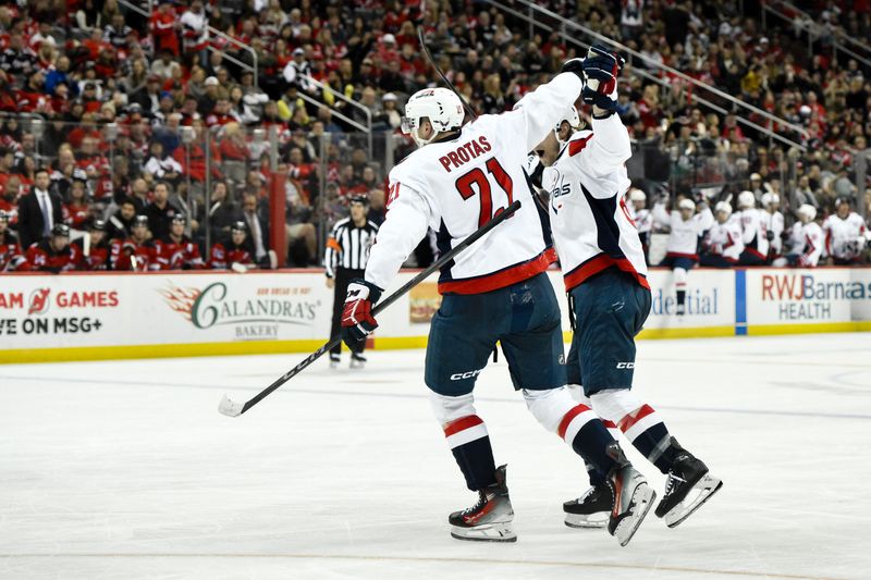 Oct 19, 2024; Newark, New Jersey, USA; Washington Capitals center Aliaksei Protas (21) and Washington Capitals defenseman Jakob Chychrun (6) react after a goal by Washington Capitals left wing Alex Ovechkin (not pictured) during the first period against the New Jersey Devils at Prudential Center. Mandatory Credit: John Jones-Imagn Images